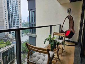 a balcony with two chairs and a swing and a window at Cosy Apartment at KL City Centre in Kuala Lumpur