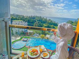 a child sitting at a table next to a pool at GoldOne Hotel & Suites in Seogwipo