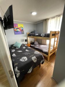 a bedroom with two bunk beds and a flat screen tv at Departamento de 3 dormitorio in Santiago