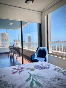 a bedroom with a bed and a balcony with a view at Depto frente a Playa con hermosa vista al mar Condominio Mar Egeo in Iquique