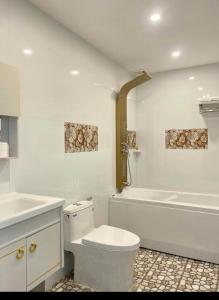 a white bathroom with a toilet and a bath tub at Khách Sạn Phụng Vy in Ap Rạch Soi