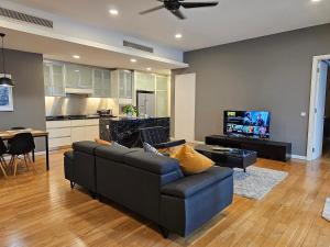 a living room with a couch and a tv at Cosy Apartment at St Mary KL City Centre in Kuala Lumpur