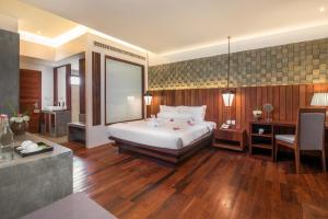 Siemreap Vasinh Residence في سيام ريب: غرفة نوم كبيرة مع سرير ومكتب ومكتب