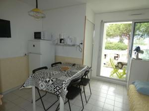 eine Küche mit einem Tisch, Stühlen, einem Tisch und einem Fenster in der Unterkunft Studio La Grande-Motte, 1 pièce, 4 personnes - FR-1-328-255 in La Grande-Motte