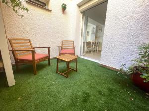 2 chaises et une table sur une cour avec de l'herbe dans l'établissement Appartement Banyuls-sur-Mer, 3 pièces, 4 personnes - FR-1-309-445, à Banyuls-sur-Mer