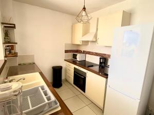 uma cozinha com armários brancos e um frigorífico branco em Appartement Les Trois-Ilets, 3 pièces, 4 personnes - FR-1-765-22 em Les Trois-Îlets