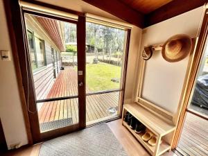 a door to a porch with a view of a yard at Albaski Lodge- Room 4 in Mount Buller