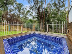 a swimming pool in front of a fence at Albaski Lodge- Room 4 in Mount Buller