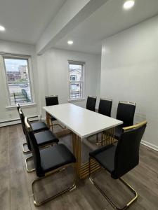 una sala conferenze con tavolo e sedie bianchi di Comfy Family Home -Adjacent To NYC: 15 Guests a Passaic