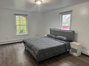 una camera con un letto e due finestre di Comfy Family Home -Adjacent To NYC: 15 Guests a Passaic