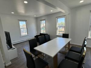 una sala riunioni con tavolo e sedie bianchi di Comfy Family Home -Adjacent To NYC: 15 Guests a Passaic