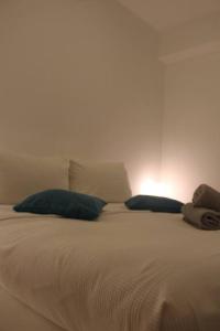 ein weißes Bett mit zwei blauen Kissen darauf in der Unterkunft Cozy Casa 2 Bedroom Apartment A Few Steps to White Beach in Boracay