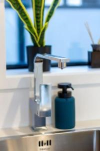 a bathroom sink with a soap dispenser on it at Deluxe Central retreat w/super king bed in Christchurch