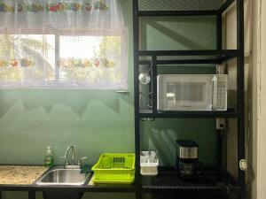 a kitchen with a sink and a microwave at Mini Suite Apartamento in San Pedro Sula +17 photos