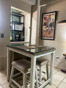 a table in a kitchen with two stools at Mini Suite Apartamento in San Pedro Sula