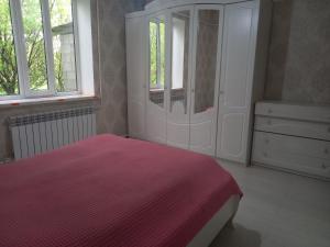 a bedroom with a bed and a dresser and windows at Zholaman in Kerben