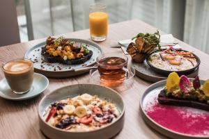 una mesa cubierta con platos de comida y bebida en Crowne Plaza Sydney Darling Harbour, an IHG Hotel en Sídney