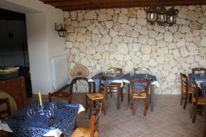 a restaurant with tables and chairs and a stone wall at Cominium Benessere in Alvito