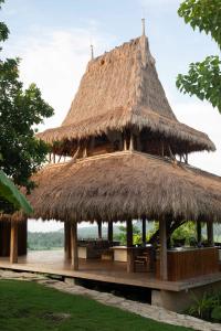 een grote hut met een rieten dak bij SumbaFarmHouse in Patiala Bawa