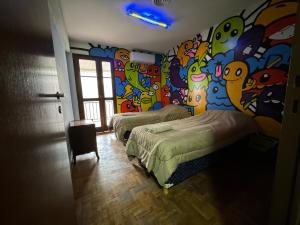 2 camas en una habitación con una pared colorida en Casa Eusebio Blanco, 5 habitaciones para 8 personas, patio, parrilla y 2 cocheras en Mendoza