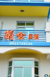 a sign on the side of a building at 澎湖菊舍民宿一館 in Magong