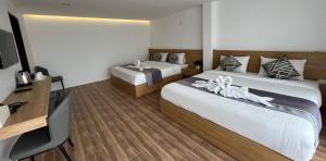Habitación de hotel con 2 camas y TV en Vang Vieng Bungalows en Vang Vieng