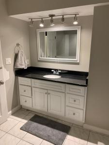 La salle de bains est pourvue d'un lavabo et d'un miroir. dans l'établissement Chelsea Condo’s, à Chelsea