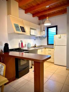 a kitchen with a counter top and a refrigerator at El Nido Bombal in Godoy Cruz