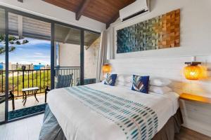 a bedroom with a bed and a balcony at 3BR Penthouse- ocean views, lanais, ACs, hot tub, pool, sauna, steps to beach in Kihei +52 photos