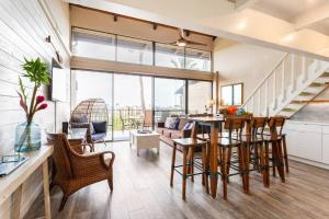 a living room with a table and chairs at 3BR Penthouse- ocean views, lanais, ACs, hot tub, pool, sauna, steps to beach in Kihei
