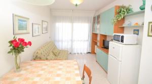 a small kitchen with a table and a microwave at Charming flat with shared pool - Beahost in Bibione