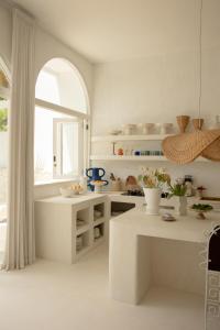 een keuken met witte werkbladen en een groot raam bij La Playa, Bali in Munggu