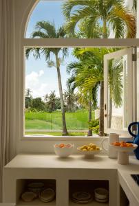 a kitchen window with a view of a palm tree at La Playa, Bali in Munggu