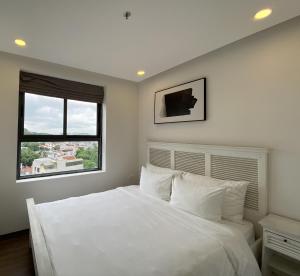 a bedroom with a white bed and a window at Mandala Apartment Hotel in Bắc Ninh