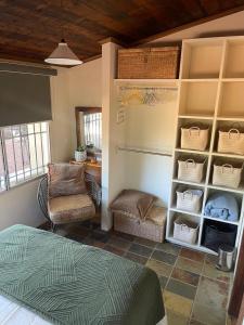a bedroom with a bed and a chair and shelves at Alice's Granny Flat in Alice Springs