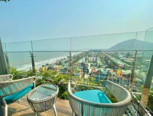a balcony with chairs and a view of the beach at Flamingo Ibiza Hải Tiến in Nam Khê