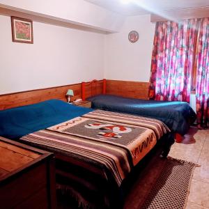 um quarto com 2 camas individuais e uma janela em Hospedaje BRC em San Carlos de Bariloche
