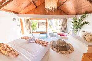 a bedroom with a large bed and a chandelier at BaraJade Villas in Uluwatu +38 photos