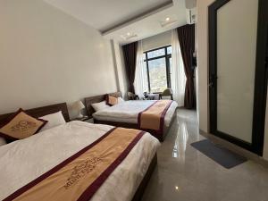 Habitación de hotel con 2 camas y ventana grande. en KHÁCH SẠN MINH ANH en San Toung