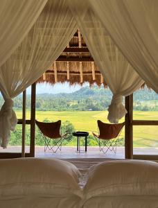 a bedroom with a bed and two chairs and a table at Sumba Farm House in Patiala Bawa