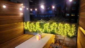 a balcony with a table with lights on it at Seoul COMOCASA Premium Terrace Residence in Seoul