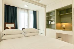 a bedroom with a white bed with white pillows at Seoul COMOCASA Premium Terrace Residence in Seoul +55 photos