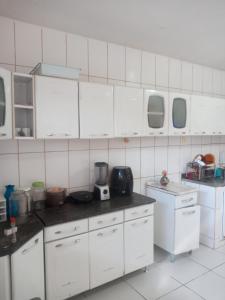uma cozinha com armários brancos e uma bancada em EXCELENTE casal mobiliada em Campina Grande