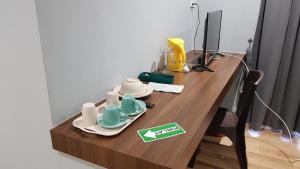 a wooden table with cups and saucers on it at Homestay KNK in Tawau