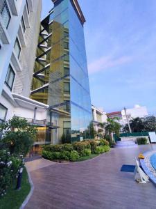 a tall glass building with a pool in front of it at Winrich Hotel in Lapu Lapu City