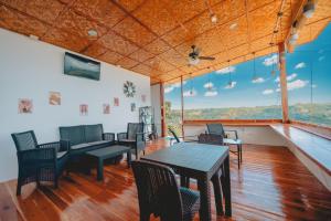 a room with a table and chairs and windows at Malabuyoc Resort Cebu in Cerdeña