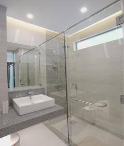 uma casa de banho com um lavatório e uma cabina de duche em vidro. em Winrich Hotel em Lapu Lapu City