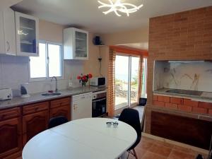 uma cozinha com uma mesa e um balcão branco em Lombada Villa Comfort em Ponta Delgada