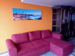 um sofá roxo numa sala de estar com um farol em Lombada Villa Comfort em Ponta Delgada