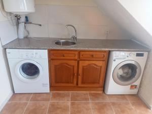 a kitchen with a sink and a washing machine at Lombada Villa Comfort in Ponta Delgada